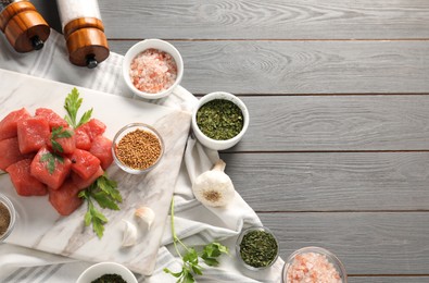 Photo of Raw beef meat and different ingredients for cooking delicious goulash on grey wooden table, above view. Space for text