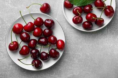 Photo of Fresh ripe cherries on light grey table, flat lay