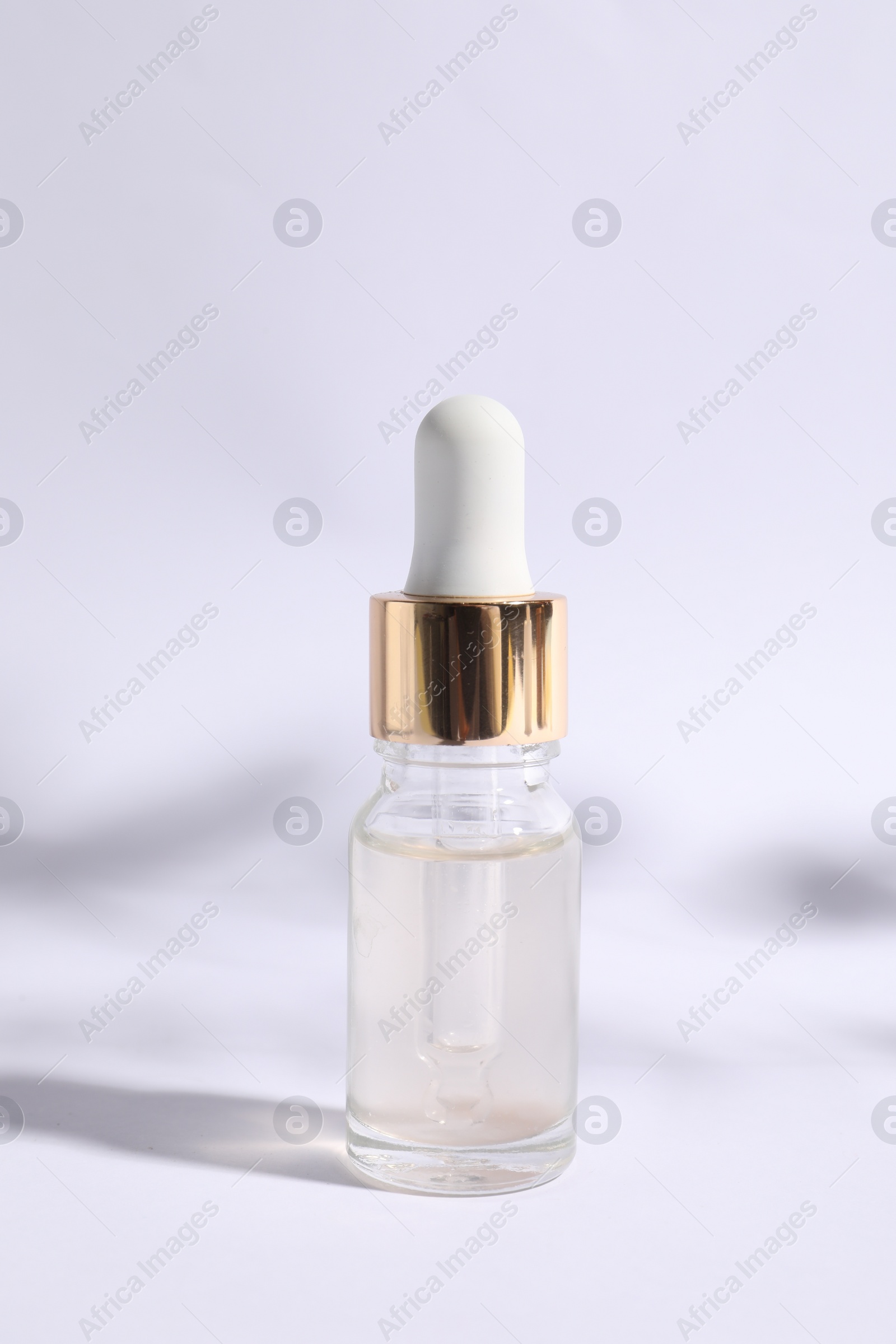 Photo of Bottle of cosmetic serum on white background