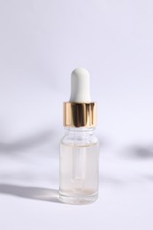 Bottle of cosmetic serum on white background