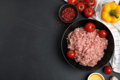 Photo of Raw chicken minced meat and ingredients on black table, flat lay. Space for text