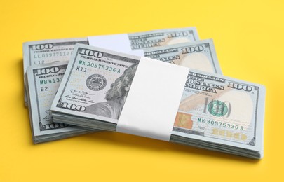 Photo of Bundles of dollar banknotes on yellow background. American national currency
