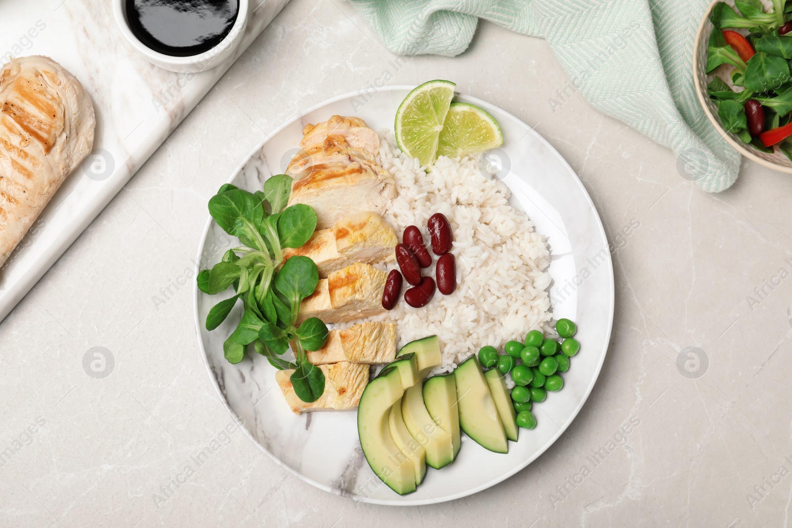 Photo of Boiled rice with vegetables and meat served on table, flat lay