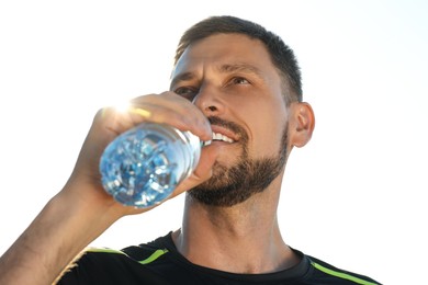 Photo of Man drinking water outdoors on hot summer day. Refreshing drink