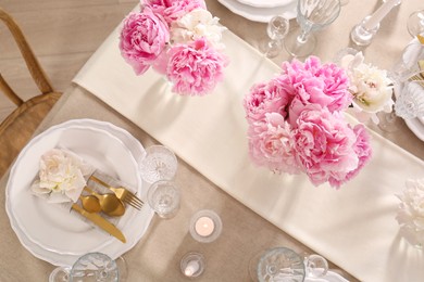 Photo of Stylish table setting with beautiful peonies and burning candles, flat lay