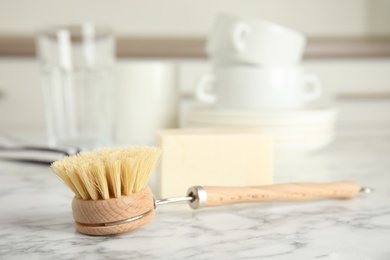 Photo of Cleaning brush for dish washing on white marble table indoors, closeup