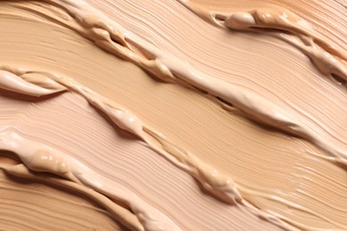 Photo of Samples of skin foundation as background, closeup