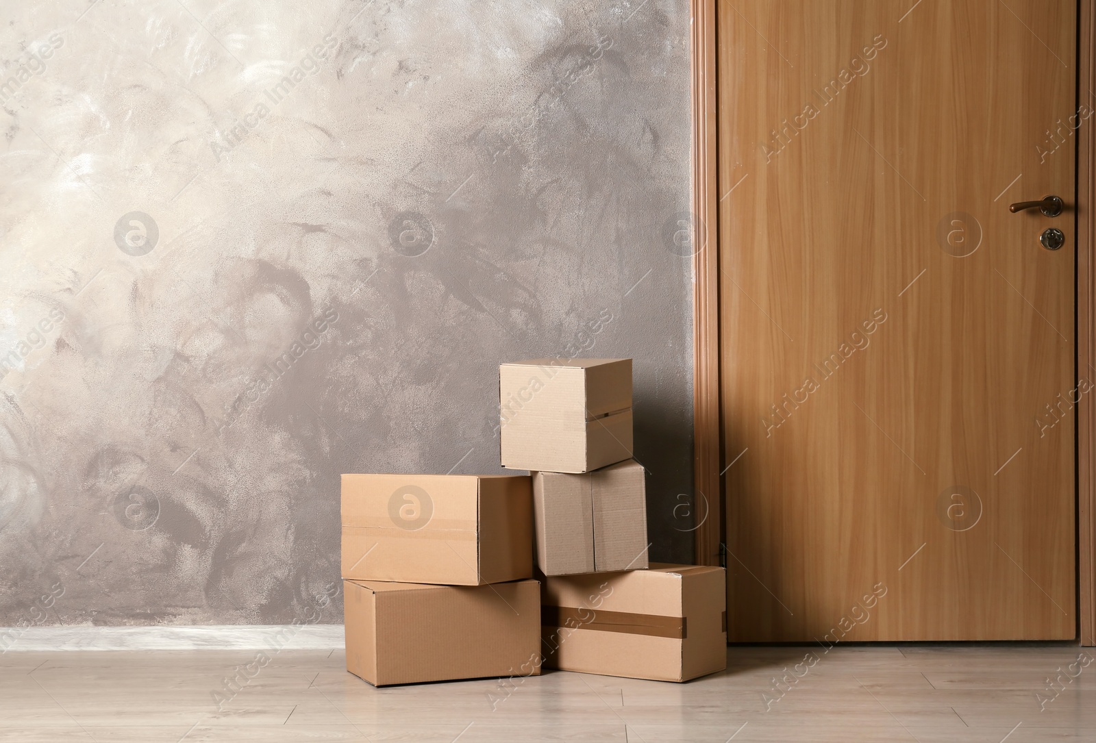 Photo of Cardboard boxes on floor near apartment entrance. Mockup for design