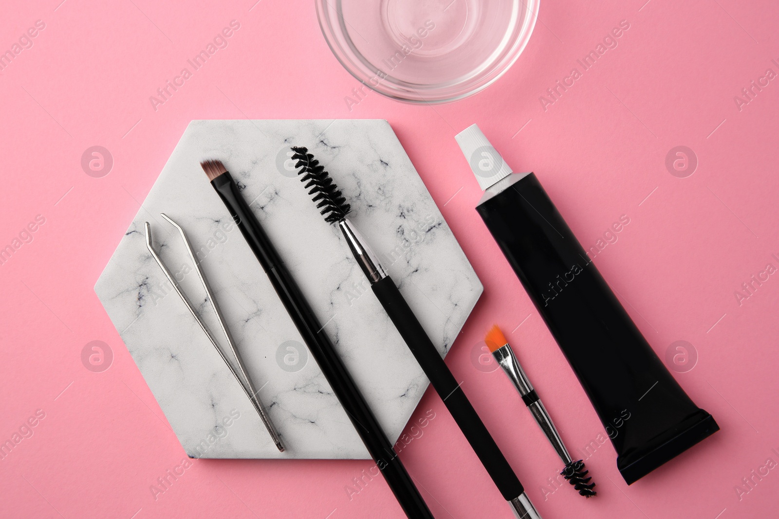 Photo of Flat lay composition with eyebrow henna and tools on pink background