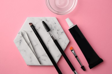 Photo of Flat lay composition with eyebrow henna and tools on pink background