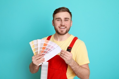 Male decorator with palette on color background