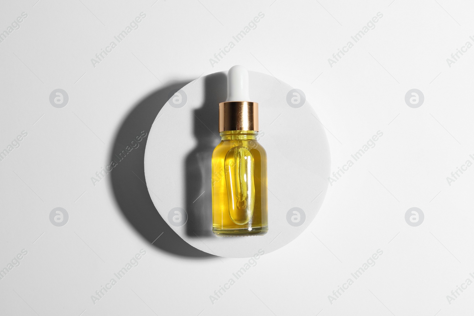 Photo of Bottle of cosmetic oil on white background, top view