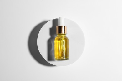 Bottle of cosmetic oil on white background, top view