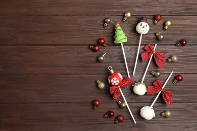 Photo of Delicious Christmas themed cake pops on wooden table, flat lay. Space for text