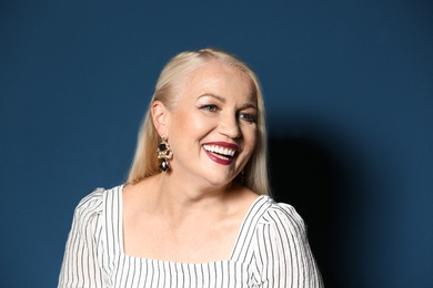 Portrait of beautiful mature woman on blue background