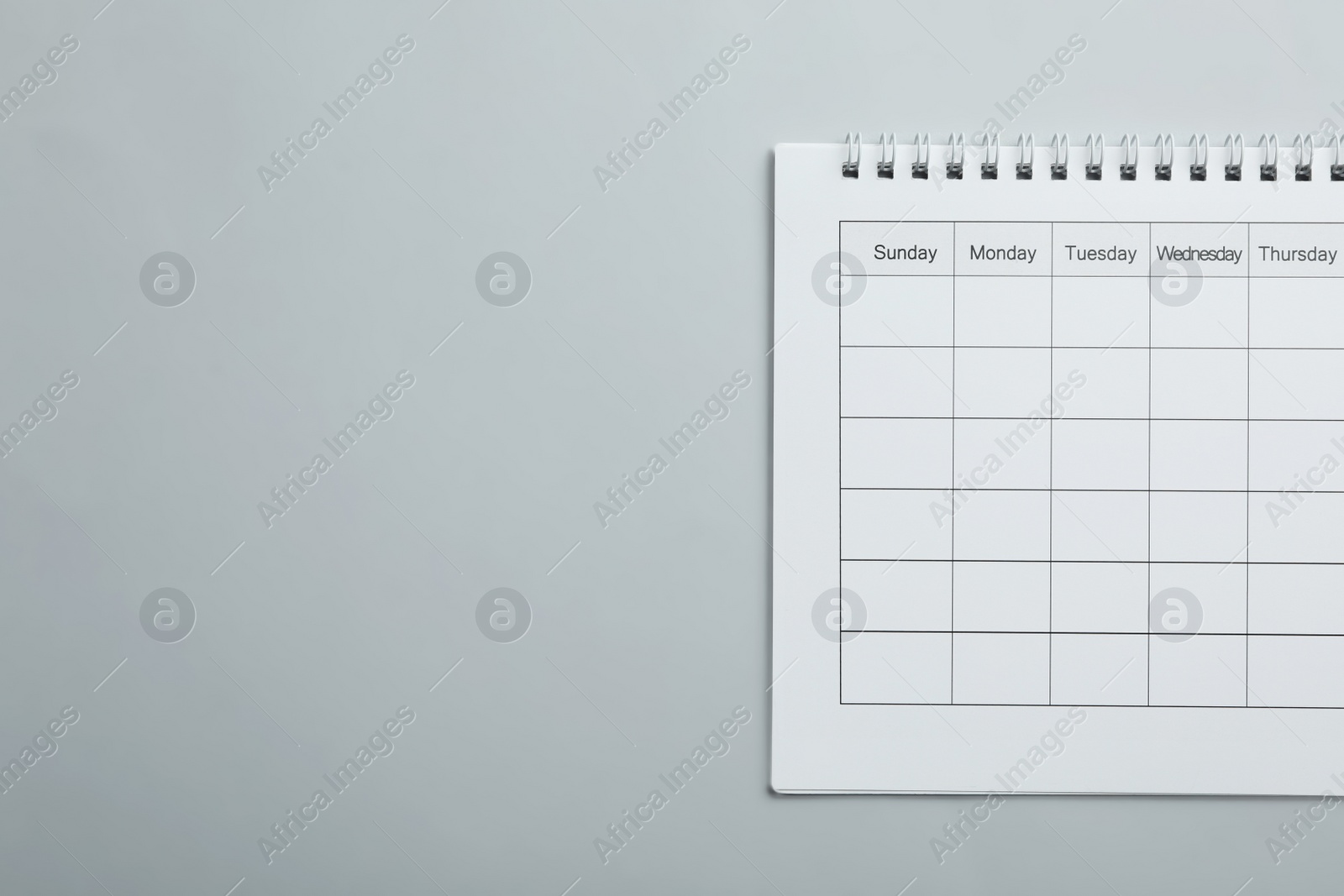 Photo of Blank calendar on light grey background, top view. Space for text