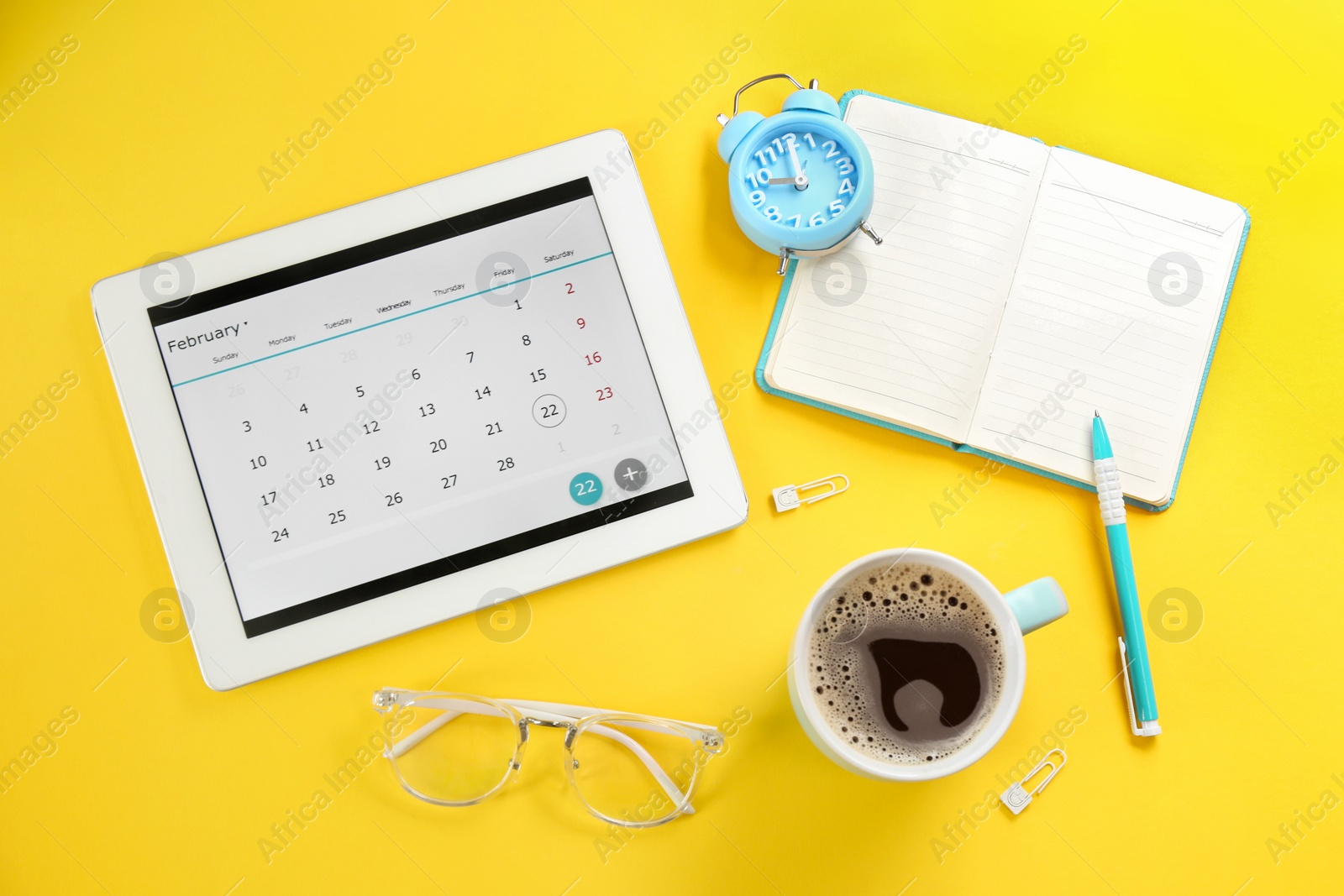 Photo of Modern tablet with calendar app on yellow background