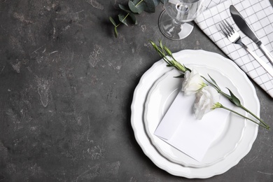 Elegant festive table setting on dark grey background, flat lay. Space for text