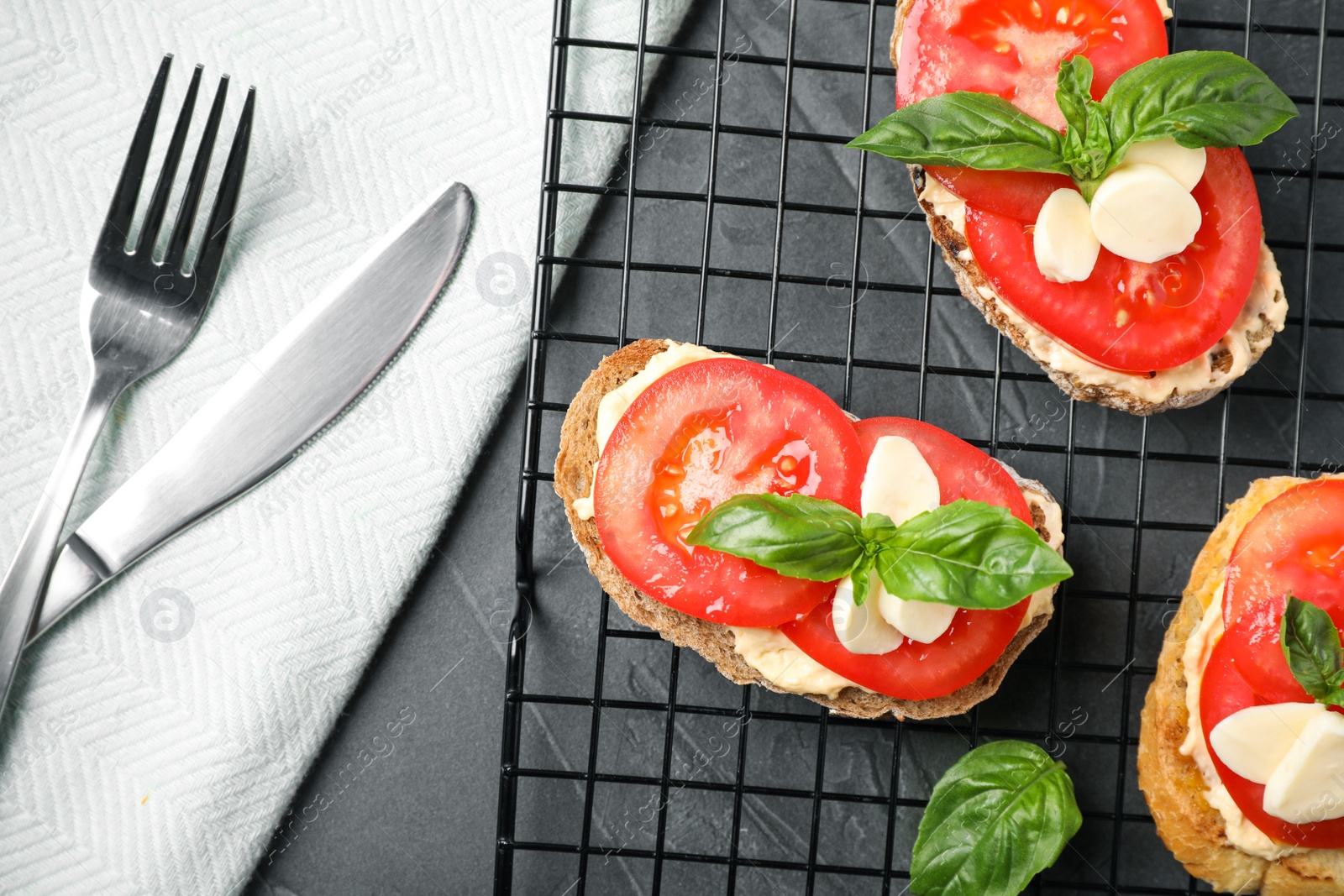 Photo of Tasty fresh tomato bruschettas on grey table, flat lay