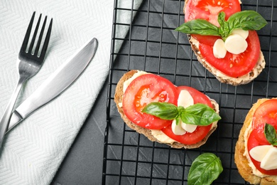 Tasty fresh tomato bruschettas on grey table, flat lay