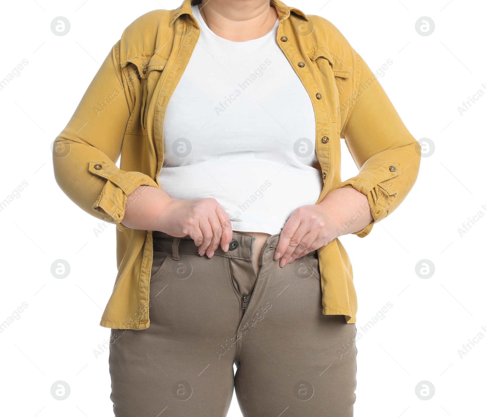 Photo of Overweight woman trying to button up tight trousers on white background, closeup