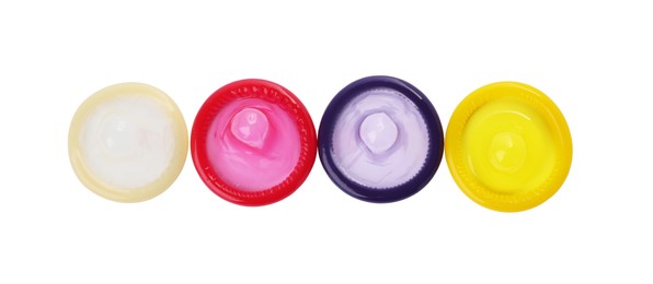 Photo of Unpacked condoms on white background, top view. Safe sex