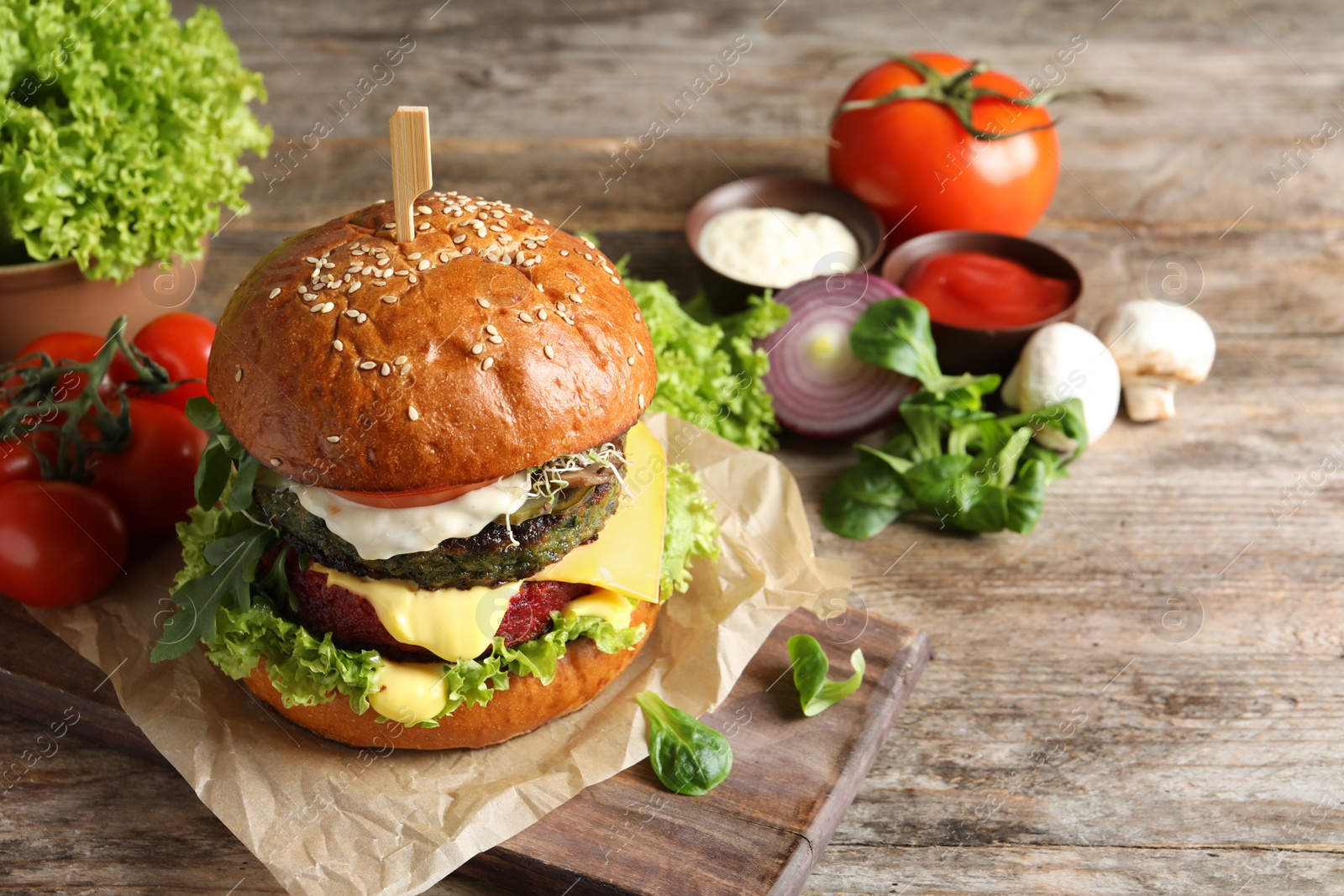 Photo of Board with vegan burger and vegetables on wooden table. Space for text