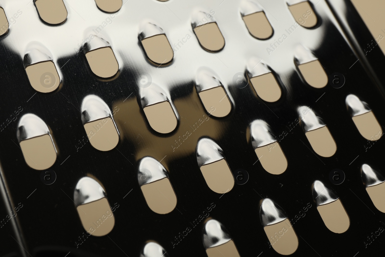 Photo of Modern metal grater as background, closeup view