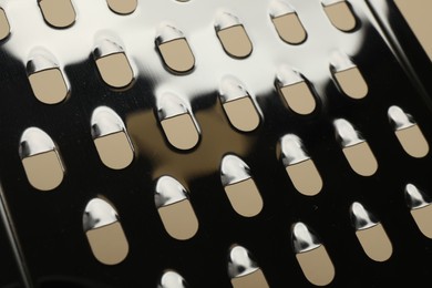 Photo of Modern metal grater as background, closeup view