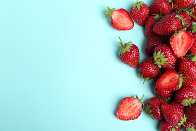 Photo of Tasty ripe strawberries on light blue background, flat lay. Space for text