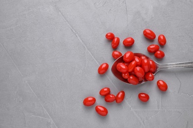 Photo of Spoon with fresh goji berries on grey background, flat lay. Space for text