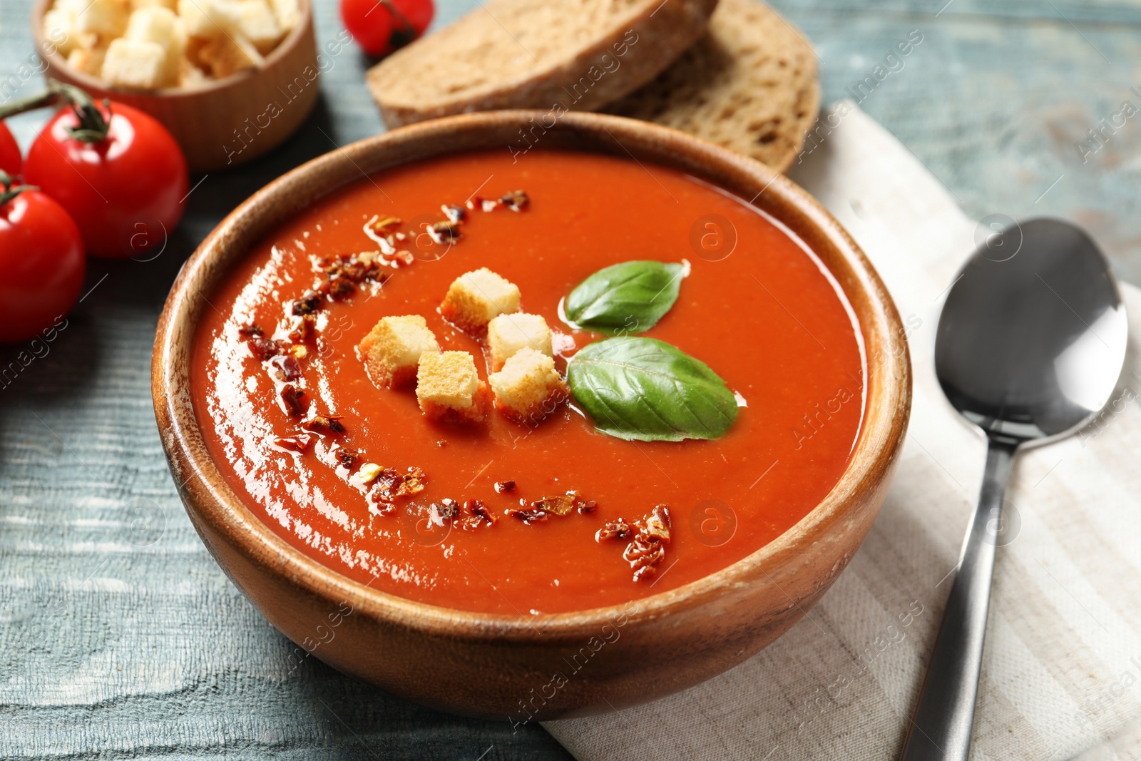 Photo of Bowl with delicious fresh homemade tomato soup on table