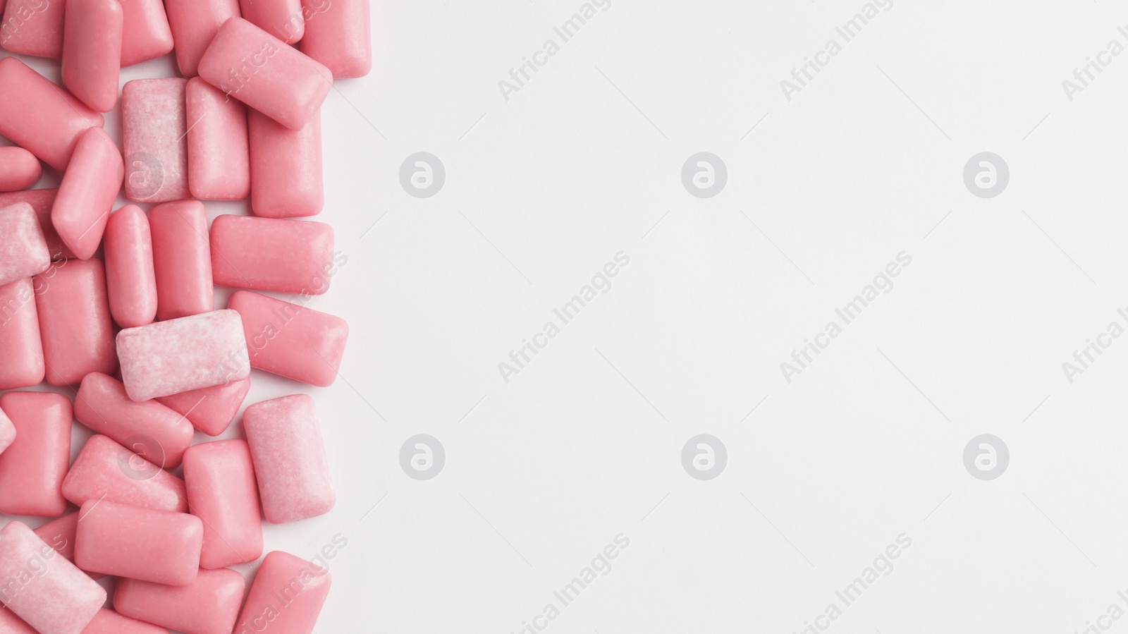 Photo of Sweet chewing gums on white background, top view. Space for text