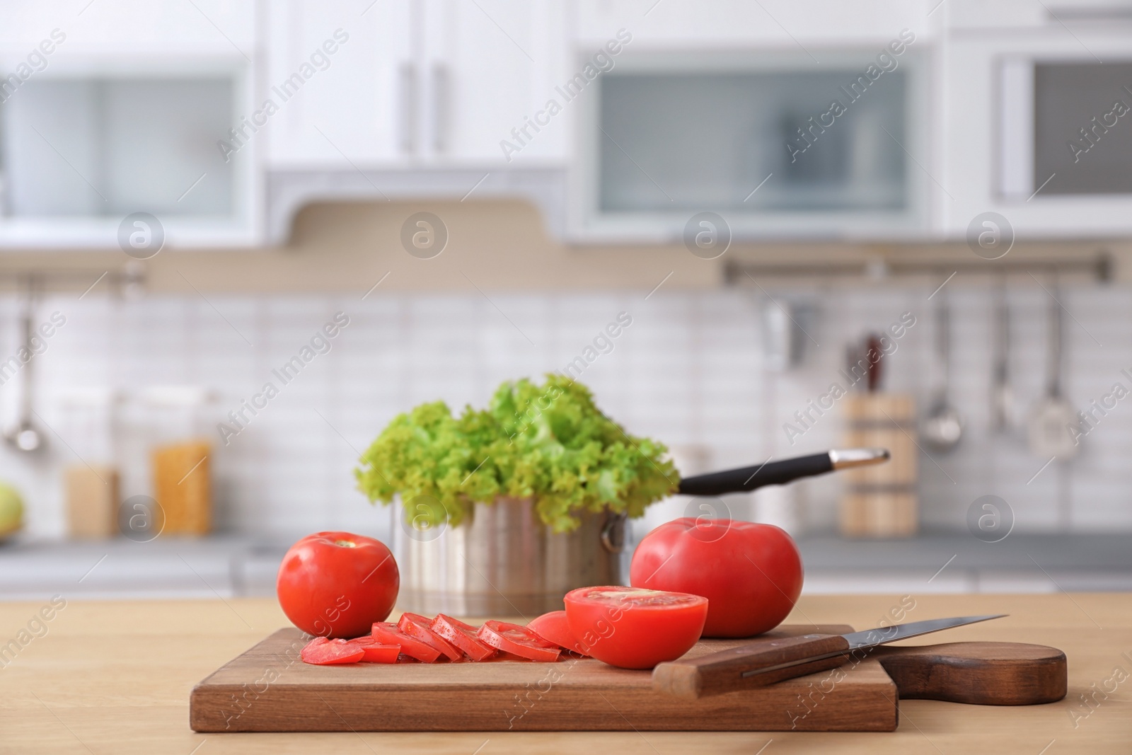 Photo of Fresh vegetables and blurred view of kitchen interior on background