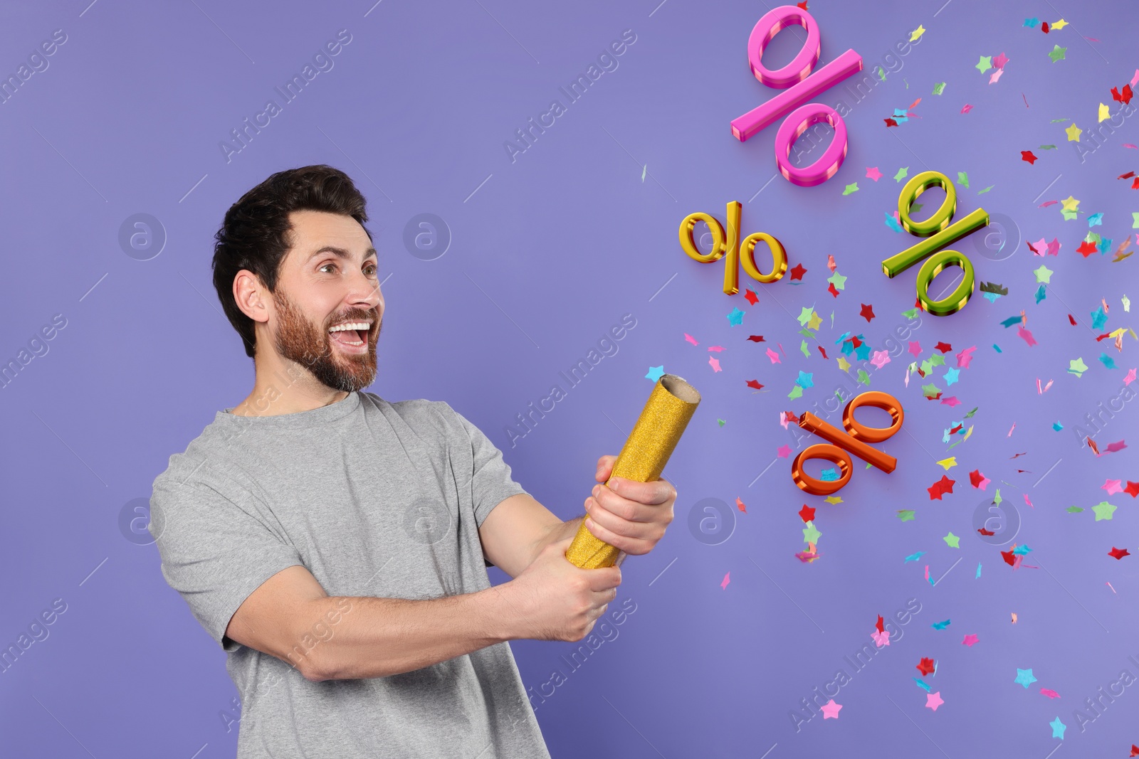 Image of Discount offer. Happy man blowing up party popper on violet background. Confetti and percent signs in air