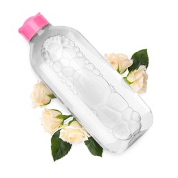 Photo of Bottle of micellar cleansing water and flowers on white background, top view