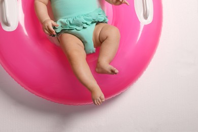 Little baby with inflatable ring on white background, top view