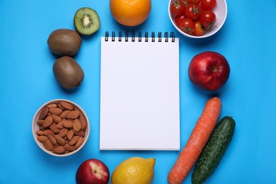 Photo of Notebook, almonds, fresh fruits and vegetables on light blue background, flat lay. Low glycemic index diet