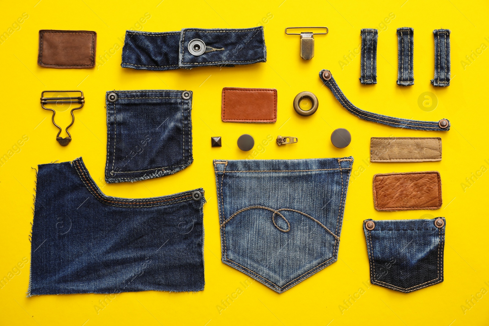 Photo of Flat lay composition with garment accessories and cutting details for jeans on yellow background