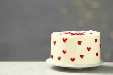 Photo of Bento cake with red cream hearts on grey table, space for text. St. Valentine's day surprise