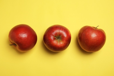 Photo of Flat lay composition with ripe juicy red apples on yellow background