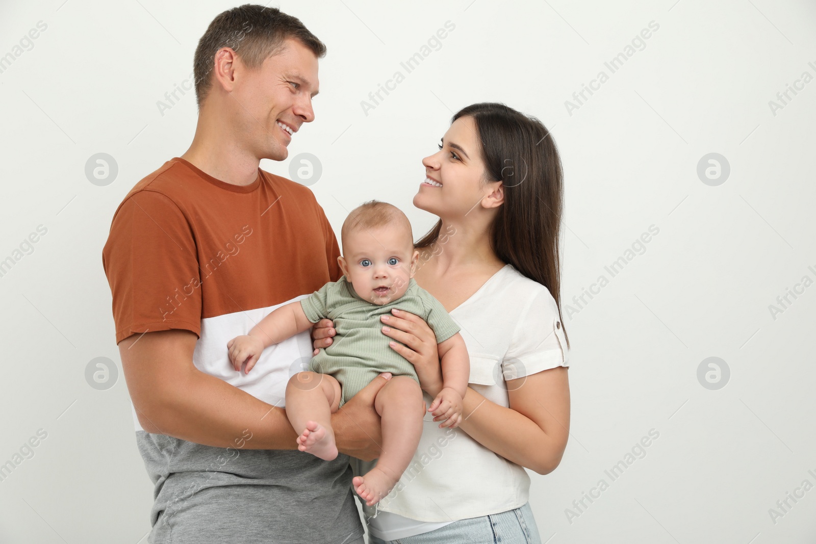 Photo of Portrait of happy family with their cute baby on white background