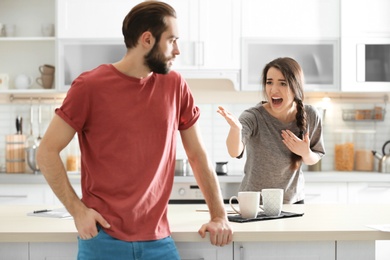 Photo of Young couple having argument in kitchen