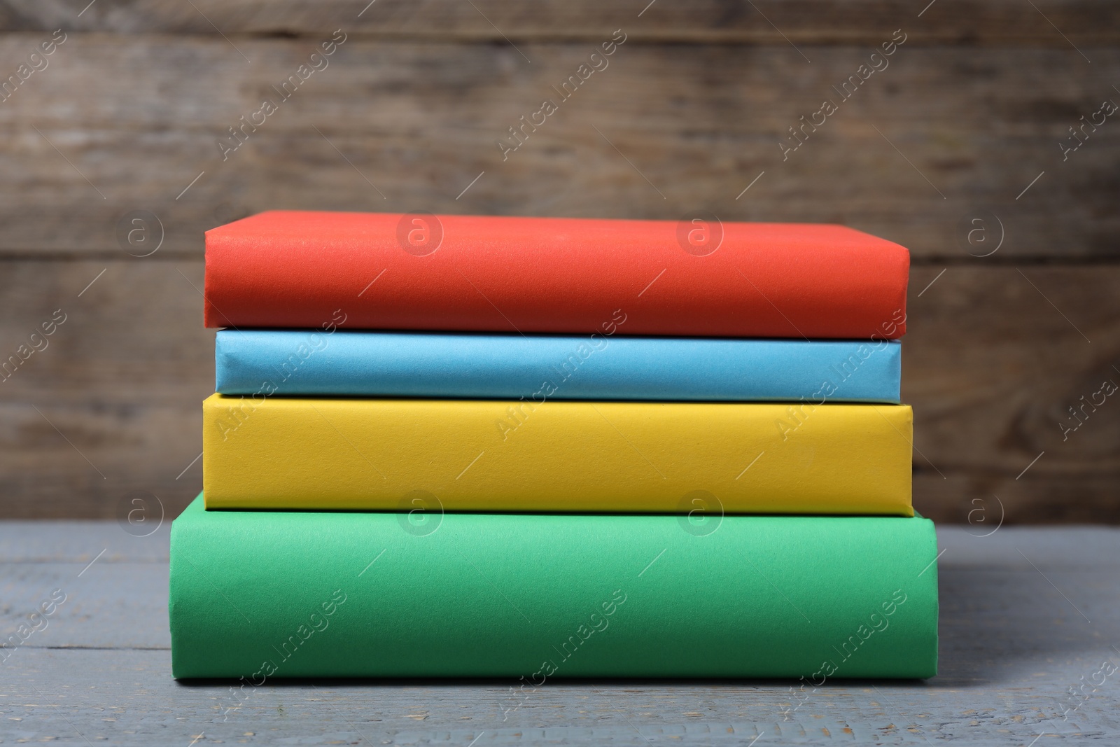 Photo of Different hardcover books on gray wooden table