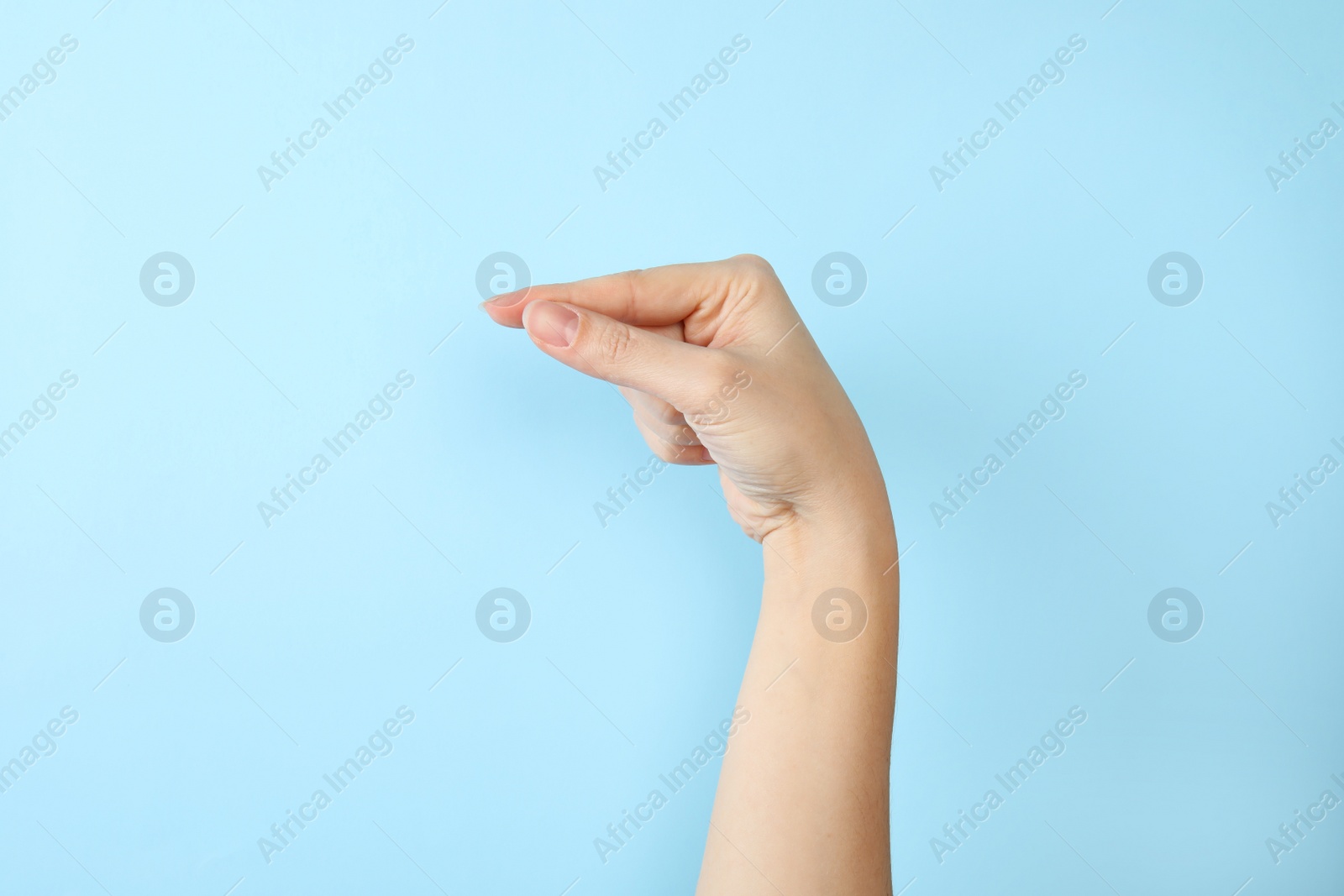 Photo of Woman showing G letter on color background, closeup. Sign language