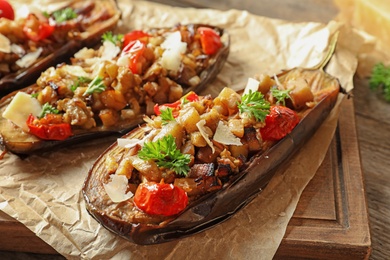 Tasty stuffed eggplants on wooden table, closeup