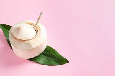 Fresh coconut drink in nut on color background