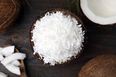 Photo of Coconut flakes and nuts on wooden table, flat lay