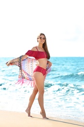 Photo of Attractive young woman in beautiful bikini swimsuit on beach