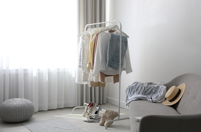 Photo of Dressing room interior with clothing rack and sofa